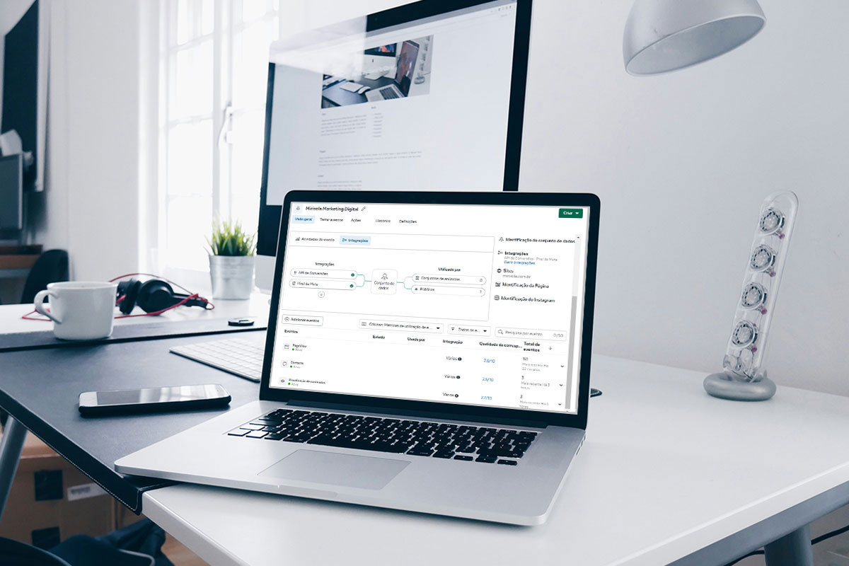 Notebook aberto sobre uma mesa de escritório branca exibe a interface do Gerenciador de Eventos do Meta Ads, mostrando métricas de integração de dados e eventos de conversão.