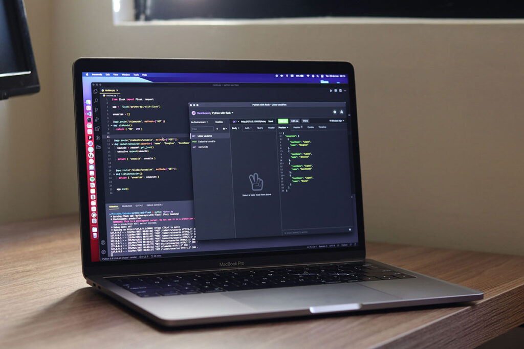 Notebook MacBook Pro aberto sobre uma mesa de madeira, exibindo uma tela de desenvolvimento web com linhas de código de programação estrutural limpo e uma ferramenta de teste de requisições de servidores.