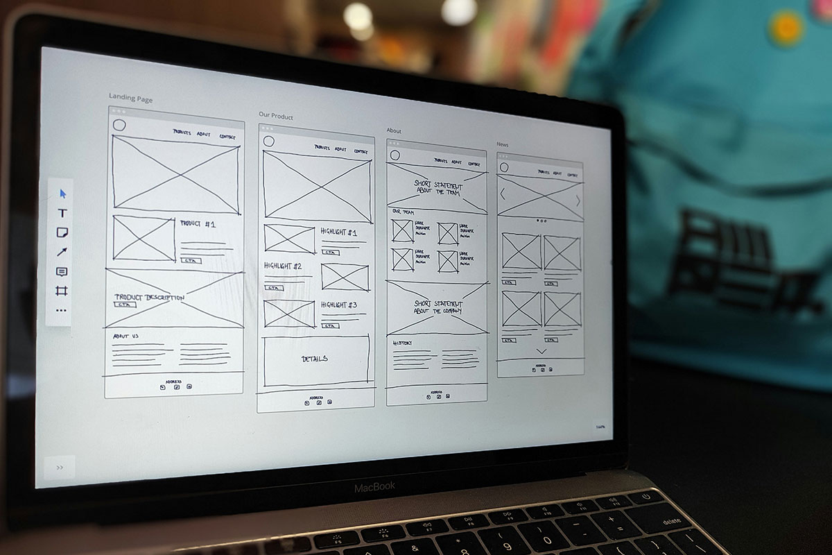 Tela de notebook exibindo wireframe digital de arquitetura de informação e layout de páginas para web design.
