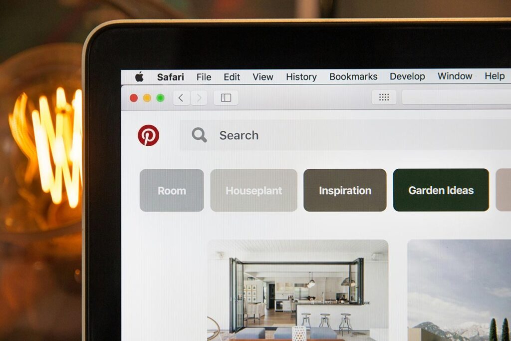 Monitor de computador exibindo a barra de pesquisa do Pinterest com botões de categorias e ideias de busca visual.