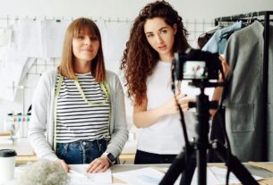 Duas influenciadoras digitais gravando vídeo em estúdio de moda para campanha de marca.